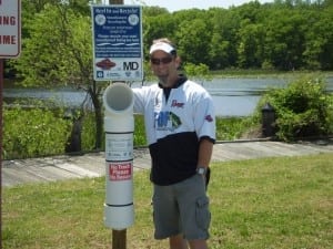 TBF of Md Conservation Director poses with one of three Monofilament Recycling bins he and his Wife, Tanya, installed at Smallwood State Park